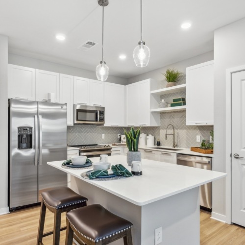 modern apartment kitchen with white cabinets, quartz countertops, and stainless steel appliances modern apartment kitchen with white cabinets, quartz countertops, and stainless steel appliances